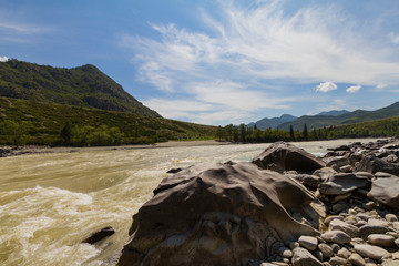 Fototapeta na wymiar Rapid current of the Chuya River in Mountains Altai. Summer time. Huge boulders on rocky coast.