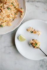 Thai fried rice in white dish and in spoon on marble table