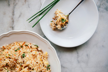 Thai fried rice in white dish and in spoon on marble table