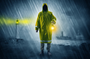 Man at the coast coming in raincoat with glowing lantern concept
