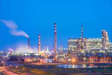 Oil refineries and oil depots and close-up of pipelines and destillation tanks of an oil-refinery plant in the evening