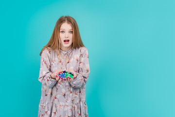 Attractive woman with poker chips isolated over turquoise blue background. Online casino concept