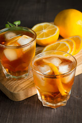 Glasses of cold ice tea with lemon, ice, mint on background. Homemade lemonade. Spring and summer drinks and beverages concept. 