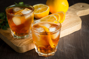 Glasses of cold ice tea with lemon, ice, mint on background. Homemade lemonade. Spring and summer drinks and beverages concept. 