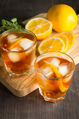 Glasses of cold ice tea with lemon, ice, mint on background. Homemade lemonade. Spring and summer drinks and beverages concept. 