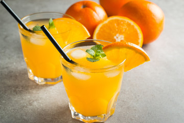 Photo of fresh orange juice in the glass jar. Summer healthy organic drink concept. Cold beverages with ice and orange fruits.