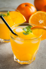 Photo of fresh orange juice in the glass jar. Summer healthy organic drink concept. Cold beverages with ice and orange fruits.