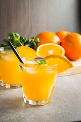 Photo of fresh orange juice in the glass jar. Summer healthy organic drink concept. Cold beverages with ice and orange fruits.