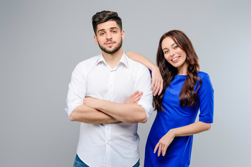 Happy and smiling young couple of man and woman isolated over grey background