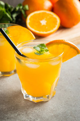 Photo of fresh orange juice in the glass jar. Summer healthy organic drink concept. Cold beverages with ice and orange fruits.