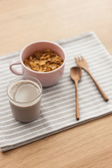 cereal with soy milk on the fabric mat, wood table for breakfast.