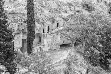Fototapeta na wymiar Massafra and its ravines. Houses built in the rock. Puglia in Black and White. Italy
