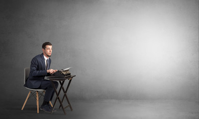 Man working hard on a typewriter in an empty space
