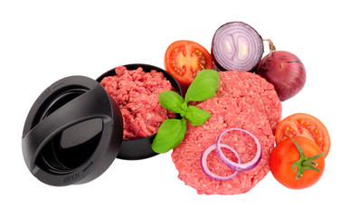 Freshly made raw beefburgers with onions, tomatoes and burger press isolated on a white background