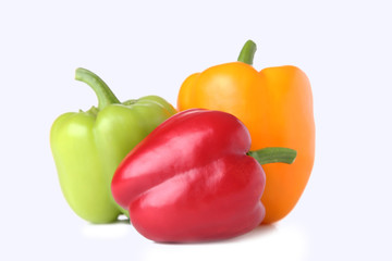 Green, red and yellow pepper on a white background
