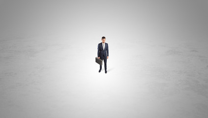 Obraz premium Young businessman standing alone in the middle of an empty space 
