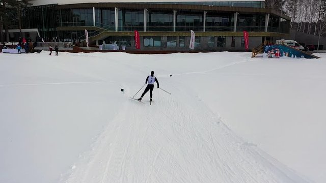 Mount skier in uniform coming to the finish line, sport concept. Footage. Man ski skating his last lap, ski championship.