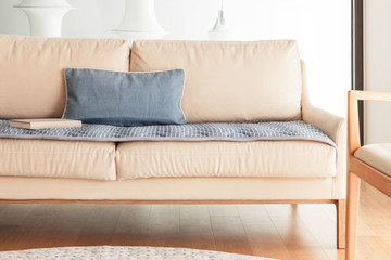 iviry sofa with blanket, cushion at the living room.