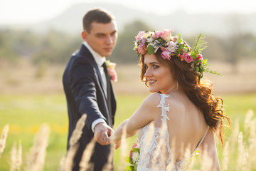 the bride and groom walk at sunset.