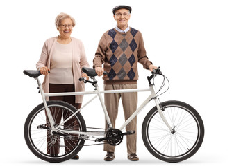 Obraz premium Senior man and woman standing with a tandem bicycle