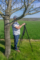 Fototapeta premium Lone photographer behind a tree