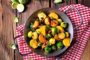 Brussels sprouts potato pan with bacon in rustic style