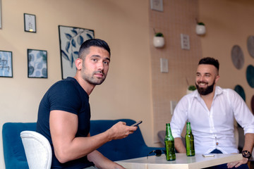 Friends toasting with beer bottles in the bar.