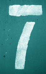 Number 7 in stencil on metal wall in cyan tone.