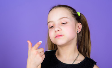 Hungry kid. Girl smiling face holds sweet marshmallows in hand violet background. Sweet tooth concept. Kid girl with long hair likes sweets and treats. Calorie and diet. Incorrigible sweet tooth