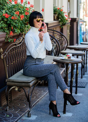 Pleasant time and leisure. Relax and coffee break. Happy to hear you. Woman attractive elegant brunette spend leisure cafe terrace background. Leisure concept. Girl fashionable lady with smartphone