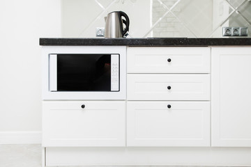 Modern white kitchen in the bright interior of the apartment