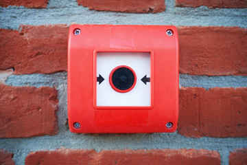 fire alarm red button on a brick wall