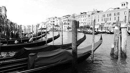 Water canal in Venezia or Venice, Italy with buildings and gondolas black and white