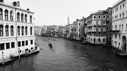 Water canal in Venezia or Venice, Italy with buildings and gondolas black and white