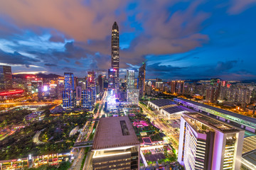 Naklejka premium Tall buildings and traffic roads in downtown shenzhen at night.
