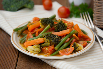 Roasted root vegetables on platte. Carrots, parsnips, broccoli, cherry tomato,, red onions, vegetable salad. Warm salad. Vegetarian food. Healthy food concept.