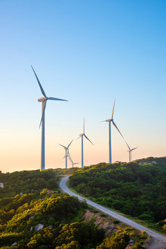 Wind turbines on the mountains are on the beach at sunrise and sunset.