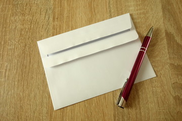 White envelope and pen on a wooden background