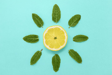Lemon slice with mint on a blue background. Minimal summer sun concept, flat lay.