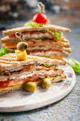 Close-up of a smoked beef sandwich on a round cutting board. Traditional breakfast or lunch. Vertical shot
