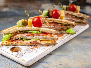 Close Up fresh slice sandwiches with beef, tomatoes and green salad. Traditional breakfast or lunch