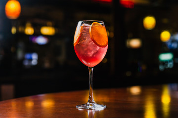 A refreshing cold cocktail with ice and orange slices in a wine glass