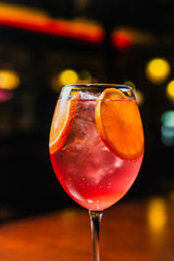 A refreshing cold cocktail with ice and orange slices in a wine glass