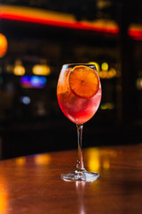 A refreshing cold cocktail with ice and orange slices in a wine glass
