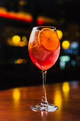 A refreshing cold cocktail with ice and orange slices in a wine glass