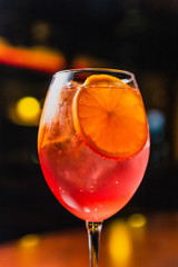 A refreshing cold cocktail with ice and orange slices in a wine glass