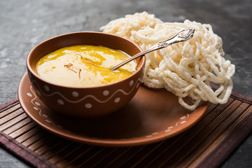 Aam Ras or Alphonso mango pulp with kurdai which is a fried dish made using wheat/gehu. selective focus