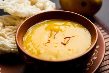Aam Ras or Alphonso mango pulp with kurdai which is a fried dish made using wheat/gehu. selective focus