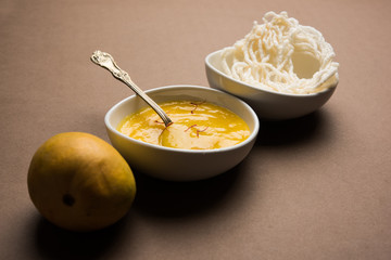 Aam Ras or Alphonso mango pulp with kurdai which is a fried dish made using wheat/gehu. selective focus