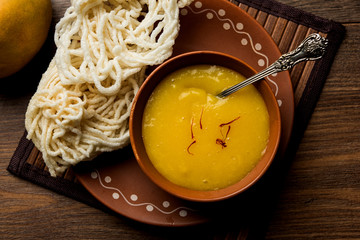 Aam Ras or Alphonso mango pulp with kurdai which is a fried dish made using wheat/gehu. selective focus